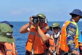 Phóng viên ảnh TTXVN Phạm Kiên tác nghiệp tại quần đảo Trường Sa. (Ảnh: TTXVN)