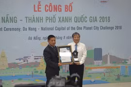 Đại diện Tổ chức Bảo tồn thiên nhiên quốc tế (WWF) tại Việt Nam (trái) trao danh hiệu Thành phố xanh quốc gia của Việt Nam cho thành phố Đà Nẵng. (Ảnh: Đinh Văn Nhiều/TTXVN)