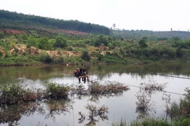 Người dân tại huyện Ngọc Hồi vượt sông bằng đu dây. (Ảnh: Quang Thái/TTXVN)