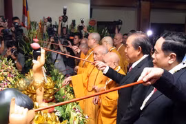Phó Thủ tướng Trương Hòa Bình, các hòa thượng, Thượng tọa và các đại biểu thưc hiện nghi Lễ tắm Phật tại Lễ mừng Phật đản. (Ảnh: Nguyễn Dân/TTXVN)