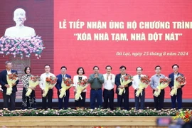 Thủ tướng Phạm Minh Chính tặng hoa cho các nhà tài trợ ủng hộ Chương trình “Xóa nhà tạm, nhà dột nát" trên địa bàn tỉnh Lâm Đồng. (Ảnh: Dương Giang/TTXVN)