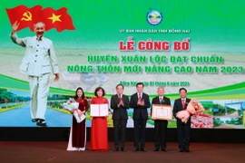 Phó Thủ tướng Trần Lưu Quang (thứ 3, trái sang) trao Quyết định của Thủ tướng Chính phủ công nhận Huyện nông thôn mới nâng cao cho lãnh đạo huyện Xuân Lộc, Đồng Nai. (Ảnh: Lê Xuân/TTXVN)