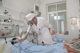 Bác sỹ Hoàng khám chữa bệnh cho bệnh nhân. (Ảnh: Trịnh Duy Hưng/Vietnam+)