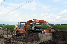 Đơn vị kiểm định chất lượng bêtông tiến hành khoan trụ bêtông cột điện cao thế để lấy mẫu kiểm định chất lượng. (Ảnh: Văn Đạt/TTXVN)