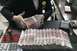 Kiểm đồng nhân dân tệ tại một điểm giao dịch ngoại hối ở Thượng Hải, Trung Quốc. (Nguồn: Reuter/TTXVN)