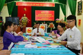 Hội đồng kiểm phiếu phân loại phiếu bầu cử. (Ảnh: Công Luật/TTXVN)