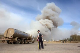 Cảnh sát làm nhiệm vụ tại khu vực đường cao tốc gần đám cháy rừng ở Fort McMurray, Alberta. (Nguồn: AFP/TTXVN)