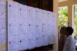 Ngư dân tại xã An Vĩnh, huyện Lý Sơn xem bảng niêm yết danh sách các ứng cử viên. (Ảnh: Sỹ Thắng/TTXVN)