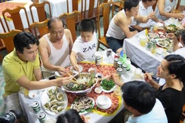 Du khách thưởng thức các món ăn hải sản tại bãi tắm Thiên Cầm. (Ảnh: Phan Quân/TTXVN)