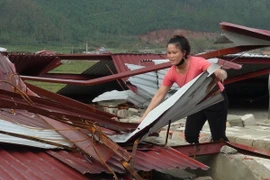 Người dân bãi ngang Quảng Đông (huyện Quảng Trạch) lợp lại mái nhà sau bão. (Ảnh: Đức Thọ/TTXVN)