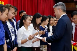 Đại biện lâm thời Đại sứ quán Việt Nam tại Lào, ông Nguyễn Thanh Tùng trao học bổng cho các con em Việt kiều. (Ảnh: Phạm Kiên/TTXVN/)