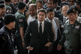 Cựu Thủ tướng Thái Lan Abhisit Vejjajiva (giữa) tới tòa án ở Bangkok ngày 12/12/2013. AFP/ TTXVN)