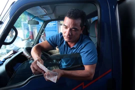 Lái xe cố tình chậm chạp trả từng đồng tiền lẻ tại trạm thu phí BOT số 1 quốc lộ 5 huyện Văn Lâm. (Ảnh: Phạm Kiên/TTXVN)