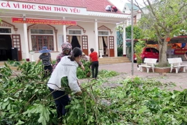 Giáo viên và phụ huynh học sinh trường THCS Kỳ Tân, huyện Kỳ Anh dọn vệ sinh môi trường. (Ảnh: Công Tường/TTXVN)