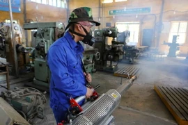 Nhân viên y tế quận Đống Đa phun thuốc tại các lớp học của Trường Cao đẳng Nghề Công ngiệp Hà Nội (131 Thái Thịnh). (Ảnh: Thành Đạt/TTXVN)