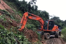 Ngay sau khi xảy ra sạt lở, đội quản lý Quốc lộ 279 đã nhanh chóng đến khắc phục, xử lý kịp thời. (Ảnh: Văn Dũng/TTXVN)