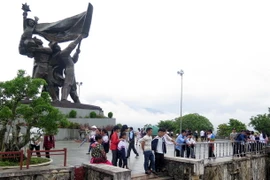 Người Mông lên tượng đài Chiến thắng trên đồi D1 để ngắm cảnh phố phường lòng chảo Mường Thanh. (Ảnh: Xuân Tiến/Vietnam+)