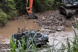 Chiếc xe bị lũ cuốn trôi làm 4 du khách thiệt mạng. (Ảnh: Nguyễn Dũng/TTXVN)