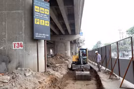 Thi công khu vực mở rộng lối vào đường Pháp Vân. (Ảnh: Huy Hùng/TTXVN)