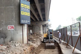 Thi công khu vực mở rộng lối vào đường Pháp Vân. (Ảnh: Huy Hùng/TTXVN)
