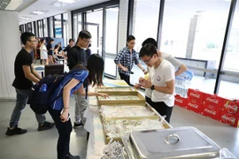 Các bạn trẻ tò mò trước quầy phở cuốn. (Ảnh: Phóng viên TTXVN tại Sydney)