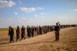 Các tay súng Tổ chức Nhà nước Hồi giáo (IS) tự xưng đầu hàng Lực lượng Dân chủ Syria được Mỹ hậu thuẫn tại Baghouz, miền Đông Syria ngày 22/2/2019. (Ảnh: AFP/TTXVN)