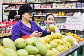 Người tiêu dùng lựa chọn trái cây. (Ảnh: Phương Anh/TTXVN)