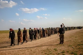 Các tay súng Tổ chức Nhà nước Hồi giáo (IS) tự xưng đầu hàng Lực lượng Dân chủ Syria được Mỹ hậu thuẫn tại Baghouz, miền Đông Syria ngày 22/2/2019. (Ảnh: AFP/TTXVN)