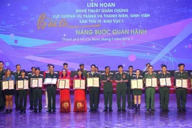 Đại diện Ban tổ chức trao Huy chương vàng cho các tập thể, cá nhân đạt thành tích cao tại liên hoan. (Ảnh: Thanh Vũ/TTXVN)