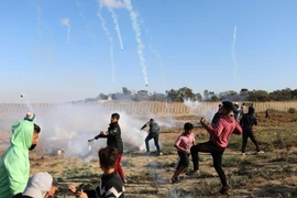 Binh sỹ Israel bắn đạn hơi cay về phía người biểu tình Palestine trong cuộc đụng độ tại khu vực biên giới Israel và Dải Gaza ngày 19/4. (Ảnh: THX/TTXVN)