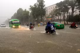 Nhiều tuyến đường thành phố Vinh bị ngập sâu khiến các phương tiện tham gia giao thông gặp nhiều khó khăn. (Ảnh: Tá Chuyên/TTXVN)