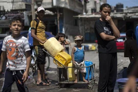 Trẻ em Palestine xếp hàng lấy nước sinh hoạt tại thành phố Gaza. (Ảnh: AFP/TTXVN)