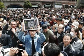 Người dân Nhật Bản tập trung tại nhà ga JR Shimbashi ở Tokyo, nghe công bố niên hiệu mới. (Ảnh: Kyodo/TTXVN)