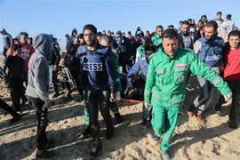 Nhân viên y tế chuyển người biểu tình Palestine bị thương tại Dải Gaza, ngày 19/3/2019. (Ảnh: THX/TTXVN)