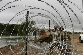 Binh sỹ Mỹ dựng hàng rào an ninh tại khu vực biên giới với Mexico ở Laredo, bang Texas (Mỹ). (Ảnh: AFP/TTXVN)