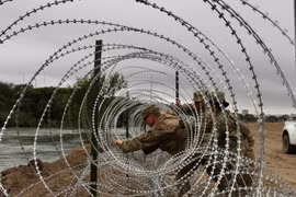 Binh sỹ Mỹ dựng hàng rào an ninh tại khu vực biên giới với Mexico ở Laredo, bang Texas (Mỹ). (Ảnh: AFP/TTXVN)