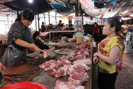 Thịt lợn tăng giá, người dân dè dặt hơn khi mua thịt lợn tại chợ Nhớn, thành phố Bắc Ninh. (Ảnh: Thanh Thương/TTXVN)