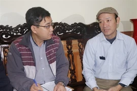 Cựu chiến binh Nguyễn Văn Kim (bên phải) đang kể lại những ký ức hào hùng về Cuộc chiến đấu bảo vệ biên giới phía Bắc. (Ảnh: TTXVN phát)