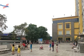 Trẻ em chơi dưới sân một khu chung cư. (Ảnh: Thanh Vũ/TTXVN)