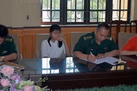 Lực lượng chức năng bàn giao hai thiếu nữ 16 tuổi bị lừa bán sang Trung Quốc. (Ảnh: Nguyễn Hoàng/TTXVN)