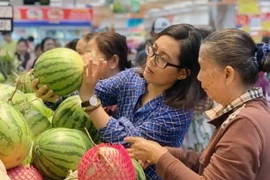Người dân chọn lựa dưa hấu tại siêu thị. (Ảnh: Mỹ Phương/TTXVN)