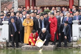 Tổng Bí thư, Chủ tịch nước Nguyễn Phú Trọng và Phu nhân thả cá chép tại hồ Hoàn Kiếm. (Ảnh: Trí Dũng/TTXVN)