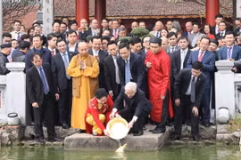 Tổng Bí thư, Chủ tịch nước Nguyễn Phú Trọng và Phu nhân thả cá chép tại hồ Hoàn Kiếm. (Ảnh: Trí Dũng/TTXVN)