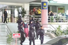 Cảnh sát dẫn giải Đoàn Thị Hương ra xe ôtô sau phiên tòa. (Ảnh: Hà Ngọc/TTXVN)