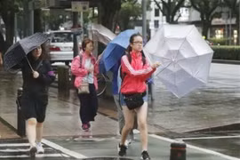 Người dân di chuyển dưới trời mưa do ảnh hưởng của bão Krosa tại Miyazaki, Tây Nam Nhật Bản, ngày 14/8/2019. (Ảnh: Kyodo/TTXVN)