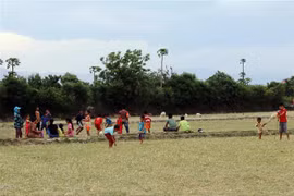 Không có sân chơi, trẻ em ở xã Phước Nam (huyện Thuận Nam, Ninh Thuận) phải đá bóng trên mặt ruộng. (Ảnh: Công Thử/TTXVN)