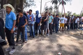 Người di cư thuộc các quốc gia vùng Trung Mỹ chờ nhận lương thực cứu trợ tại Matias Romero, bang Oaxaca, Mexico . (Nguồn: AFP/TTXVN)