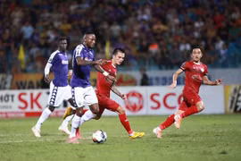 Hà Nội FC (áo tím) gặp đội Hồ Chí Minh FC (áo đỏ). (Ảnh: Trọng Đạt/TTXVN) 