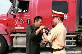 Cảnh sát giao thông tiến hành kiểm tra nồng độ cồn của lái xe khách trên cao tốc Hà Nội-Ninh Bình. (Ảnh: Doãn Tấn/TTXVN)