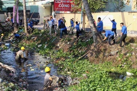 Các lực lượng dọn dẹp vệ sinh môi trường trên rạch Đất Sét, Thành phố Hồ Chí Minh. (Ảnh: Xuân Dự/TTXVN)